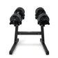 Black adjustable dumbbell stand with two cylindrical weights and double-leg base, viewed from front on white background
