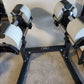 NÜOBELL adjustable dumbbell stand with white and black weight plates in black metal frame on gray carpet