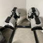 Black and white adjustable dumbbell stand with two dumbbells, NÜOBELL branding visible on horizontal bar, on concrete floor
