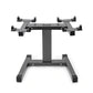 NÜOBELL adjustable dumbbell stand with gray steel single-legged base and multiple black clamps, displayed on white background