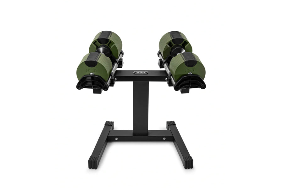 Pair of green and black adjustable dumbbells mounted on black single-legged stand against white background