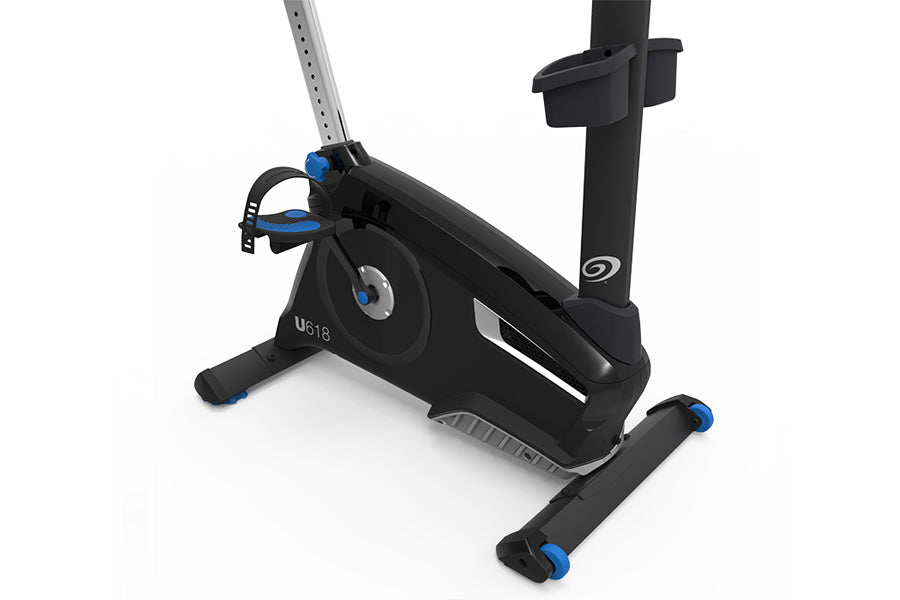 Black upright exercise bike with blue accents, adjustable seat, handlebars, and foot pedals on white background