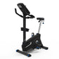 Black and silver upright exercise bike with blue accents, padded seat, handlebar display, and footrest on white background