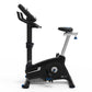 Black and silver upright exercise bike with padded seat, handlebar arms, and digital display console on white background
