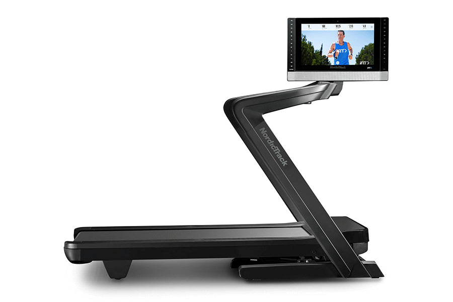 Black NordicTrack treadmill with angled touchscreen display showing athlete in blue shirt, viewed from side angle on white ba