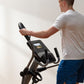 Man wearing white t-shirt using black NordicTrack elliptical with digital display console