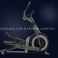 Silver and black commercial elliptical machine with dual handles and foot pedals on dark background