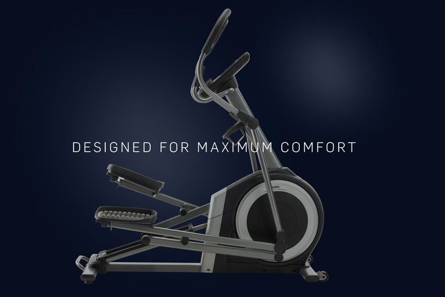 Silver and black commercial elliptical machine with dual handles and foot pedals on dark background
