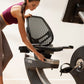 Woman in burgundy sports bra and tan leggings using NordicTrack R35 recumbent exercise bike with black mesh seat and silver f
