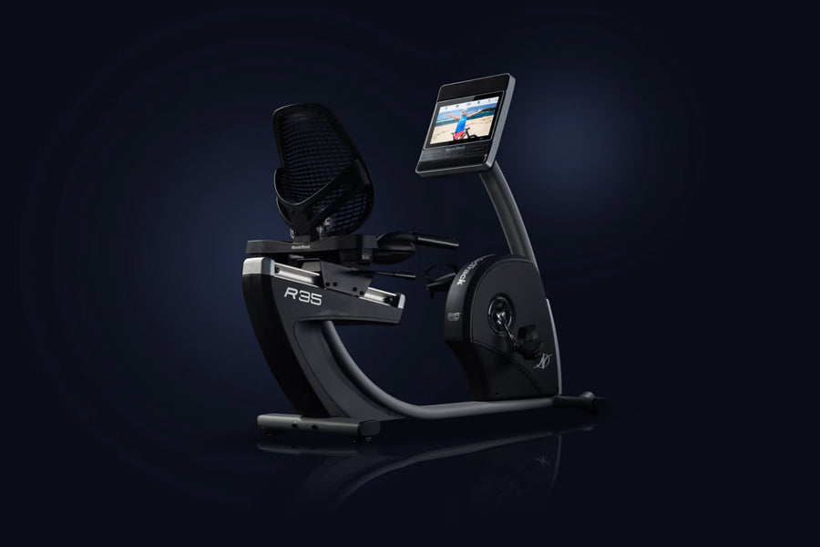 Black and gray NordicTrack Commercial R35 recumbent exercise bike with digital touchscreen display and adjustable fan on dark