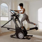 Woman using black NordicTrack FS14i elliptical machine with digital display in bright home gym setting