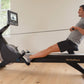 Man using black NordicTrack rowing machine with digital display in home gym setting