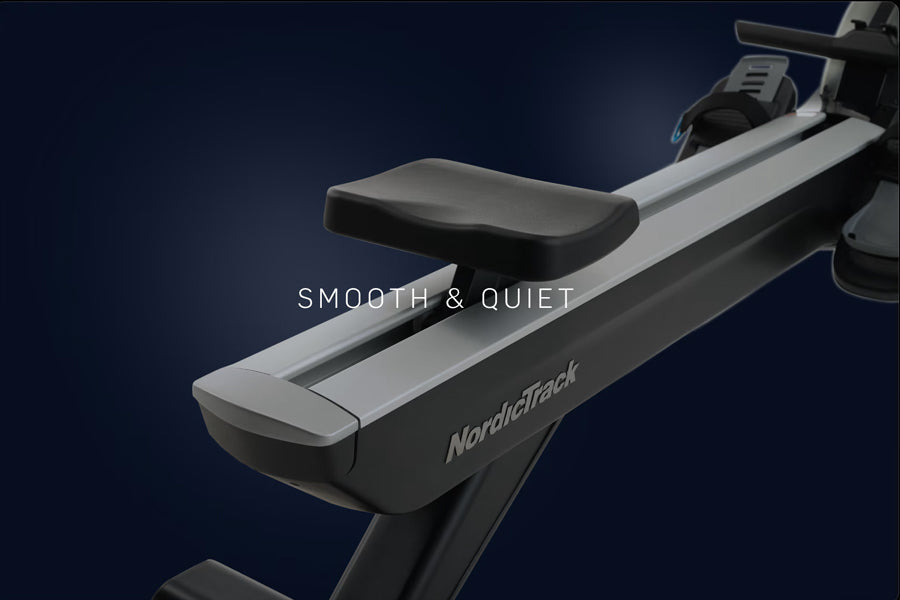 NordicTrack RW700 rowing machine with black and silver frame, padded seat, and digital console on dark blue background
