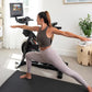 Woman performing lunge exercise on black mat in front of NordicTrack S10i stationary bike with screen display in home gym set