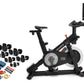 Black NordicTrack S10i indoor exercise bike with tablet display mounted on handlebar, shown with included accessories bundle 