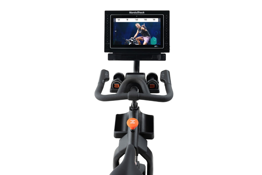 NordicTrack S15i stationary exercise bike with black frame, curved gray handlebars, orange console button, and touchscreen di
