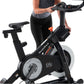 Person using black and gray NordicTrack S15i stationary bike with orange accents and digital display