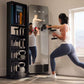 Woman in white tank top and navy leggings using interactive fitness mirror with dumbbell weights, displaying workout instruct