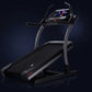 Black NordicTrack X22i commercial treadmill with curved gray frame, digital touchscreen console, and wide running belt on dar