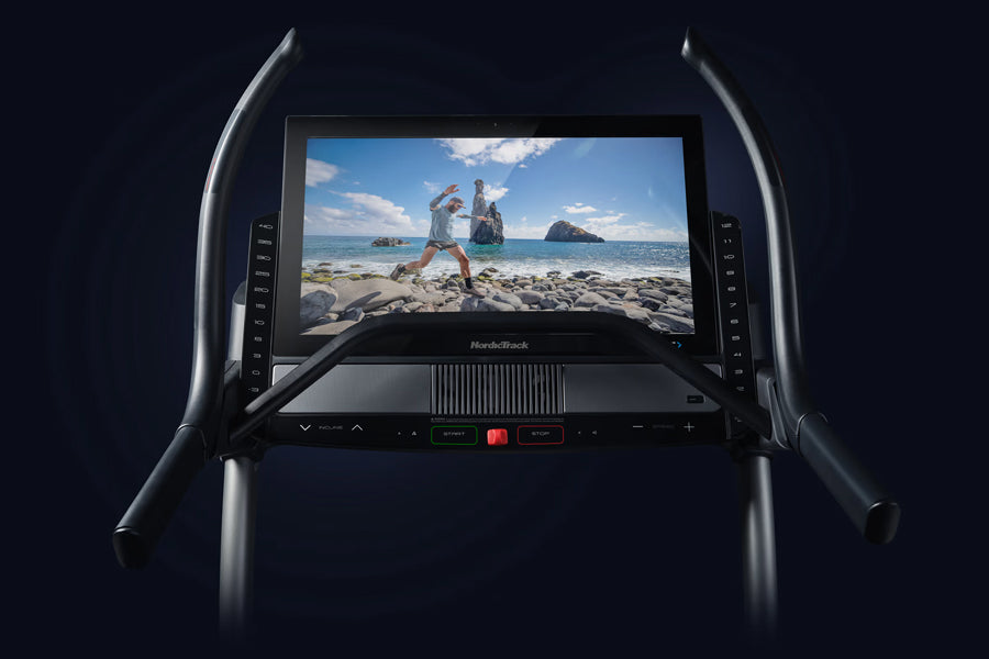 NordicTrack X32i commercial treadmill with black curved handles and digital touchscreen display showing beach workout scene, 
