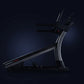 Black and silver commercial treadmill with curved console and digital display on dark background