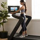 Woman in gray sports bra and black leggings using NordicTrack treadmill with interactive screen display in home setting