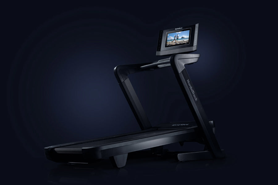 NordicTrack 1750 Commercial treadmill with black frame, wide running deck, and integrated touchscreen display showing scenic 