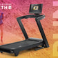 Black NordicTrack treadmill with touchscreen display and running deck, shown on gradient pink and orange background with athl