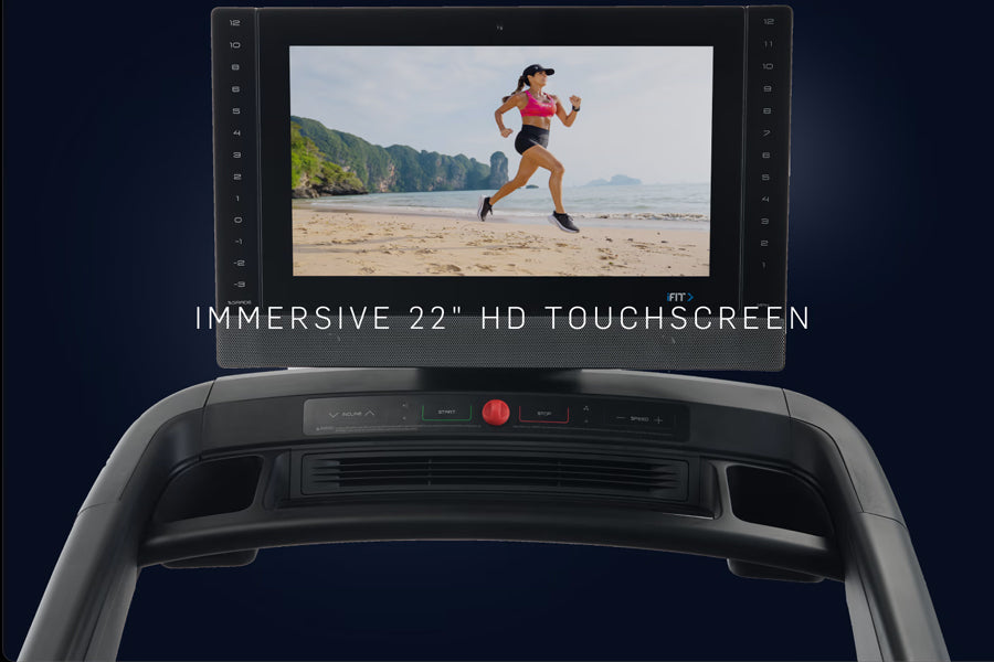 NordicTrack 2450 commercial treadmill with 22-inch HD touchscreen displaying beach running scene, black frame with control pa