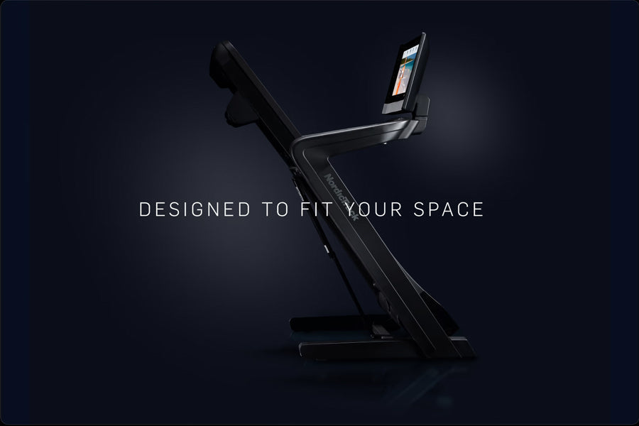 Black NordicTrack commercial treadmill with folding design and touchscreen display on dark background