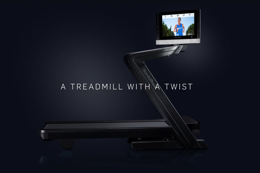 Black NordicTrack commercial treadmill with twist feature and attached display screen showing fitness video on dark backgroun