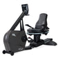 Black recumbent exercise bike with padded seat, digital display console, and foot pedals on white background