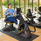 Woman in blue shirt and navy pants using black and yellow recumbent elliptical stepper in gym setting with windows