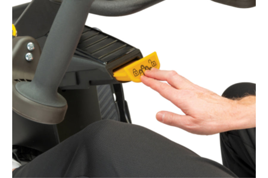 Person's hand inserting yellow key into black NuStep T6MAX recumbent elliptical machine control panel
