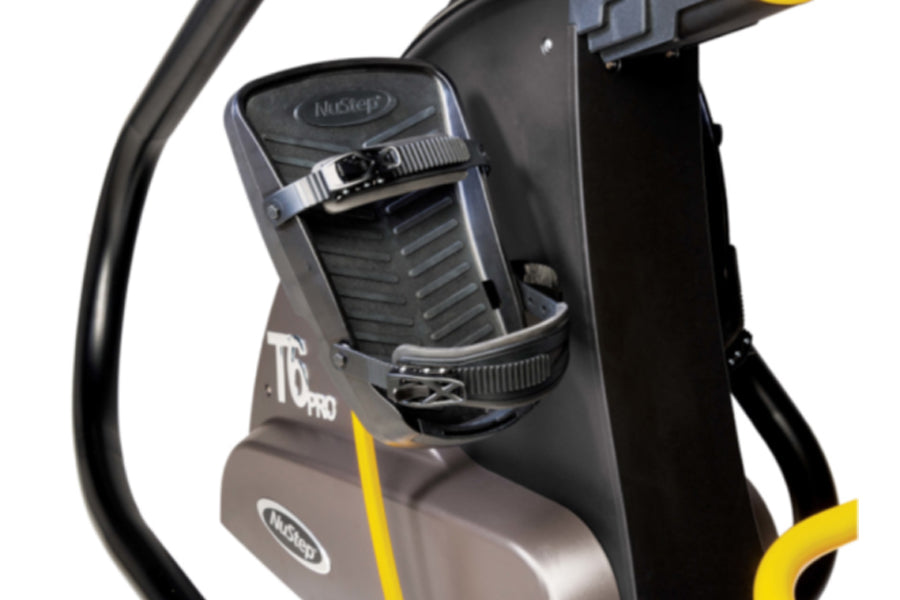 NuStep T6 Pro recumbent elliptical stepper with black frame, gray seat, yellow accents, and adjustable foot pedals on white b