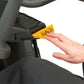 Hand inserting yellow key into NuStep T6PRO recumbent elliptical stepper, showing access panel on black machine