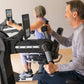 Man and woman using black NuStep UE8MAX upper body ergometer with tablet display and resistance handles in home gym setting