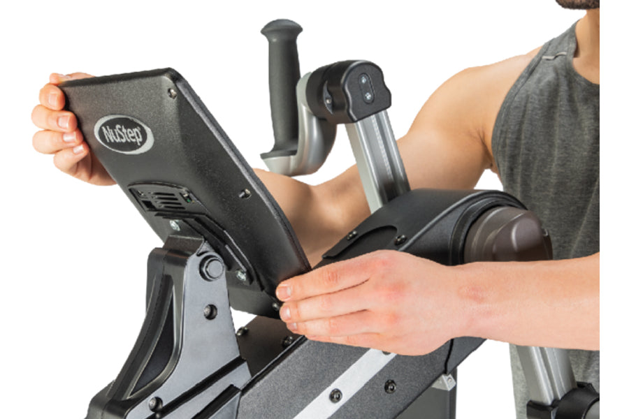 Person using NuStep UE8MAX upper body ergometer with black console and dual handles, shown on white background