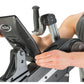 Person holding black and gray NuStep upper body ergometer console with display screen, showing fitness equipment detail