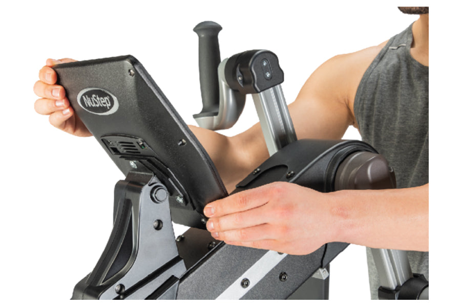 Person holding black and gray NuStep upper body ergometer console with display screen, showing fitness equipment detail