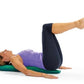 Woman lying on green foam roller wearing purple tank top and black leggings, demonstrating exercise position on white backgro