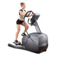 Woman using gray and black elliptical machine with digital display against white background
