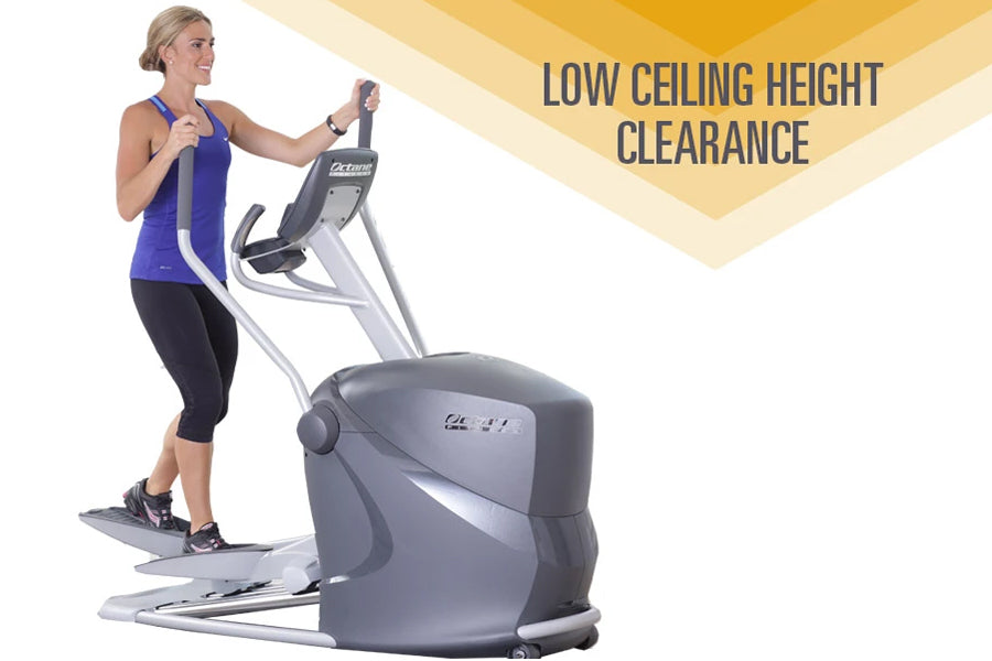 Woman in blue tank top and black capris using compact gray and silver elliptical machine with low ceiling clearance on white 