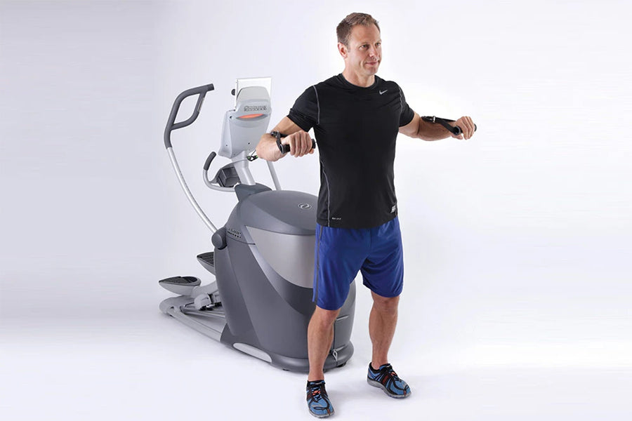 Man wearing black t-shirt and blue shorts exercising on Octane Q47x gray and white elliptical machine against white backgroun