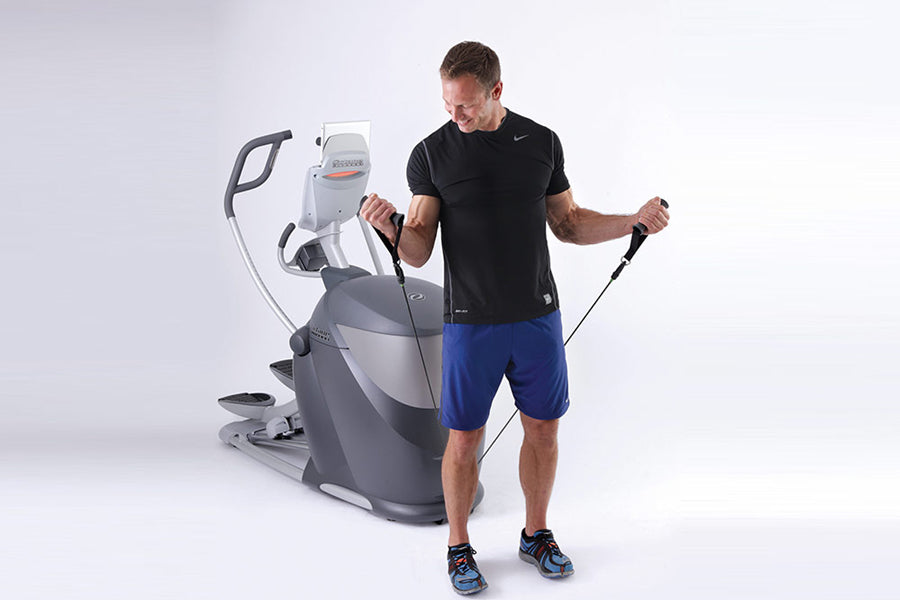 Man wearing black t-shirt and blue shorts using Octane Q47x gray and white elliptical machine with jump rope on white backgro