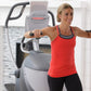 Woman wearing red tank top and black pants using gray and black elliptical machine with extended arms on handles