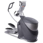 Gray and black elliptical machine with dual handles and foot pedals on white background