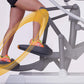 Person using gray elliptical machine with yellow motion graphics overlay showing leg movement, wearing red and orange athleti