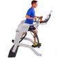 Man in blue shirt and black shorts exercising on Octane Fitness ZR7 elliptical machine with gray frame and black foot pedals