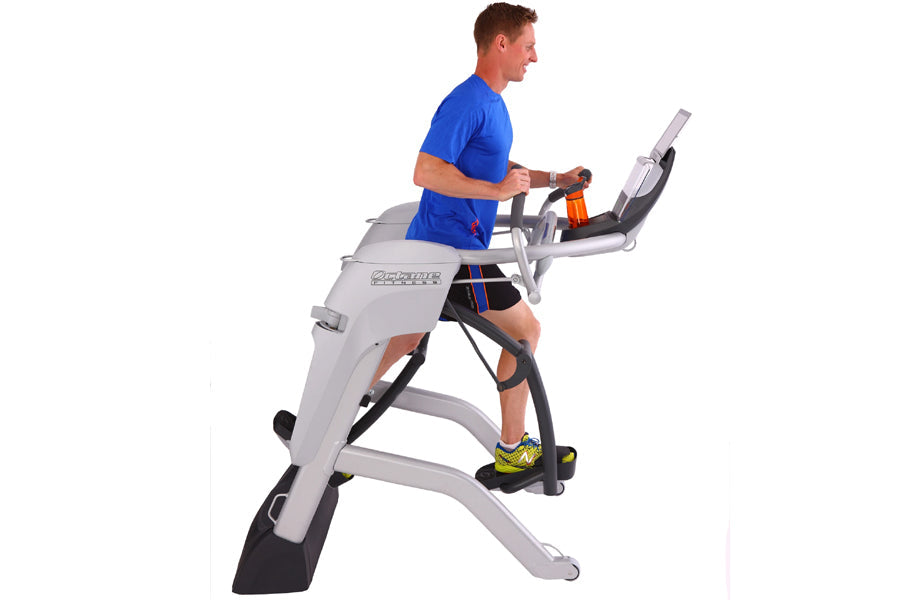 Man in blue shirt and black shorts exercising on Octane Fitness ZR7 elliptical machine with gray frame and black foot pedals
